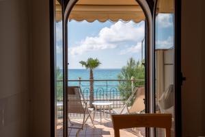 um quarto com vista para o oceano a partir de uma varanda em Residence L'Arcipelago Appartamenti Fronte Mare con Ampio Balcone em Capo dʼOrlando