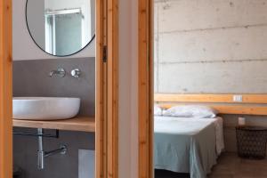 a bathroom with a sink and a mirror and a bed at Sa Guardia de Ferricci in Solanas