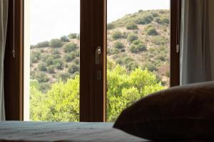 a bedroom with a window with a view of a mountain at Sa Guardia de Ferricci in Solanas