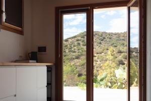 a kitchen with a window with a view of a mountain at Sa Guardia de Ferricci in Solanas
