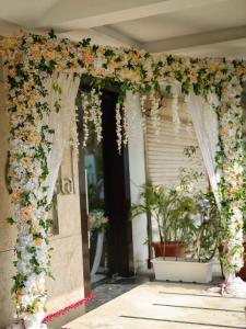 wejście do domu z łukiem kwiatowym z kwiatami w obiekcie Hotel DS Clarks Inn Gurgaon w mieście Gurgaon