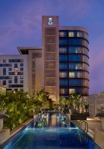 un hôtel avec une piscine en face d'un bâtiment dans l'établissement The Ritz - Carlton, Bangalore, à Bangalore