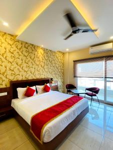 a bedroom with a large bed with red pillows at Hotel Singla Residency in Kangra