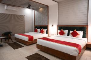 a hotel room with two beds with red pillows at Hotel Singla Residency in Kangra