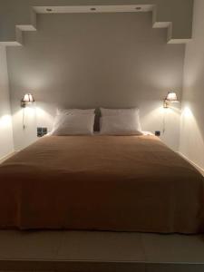 a bedroom with a large bed with two lights at Varkiza Lux Apartment in Varkiza