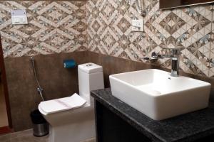 a bathroom with a sink and a toilet at Hotel Singla Residency in Kangra