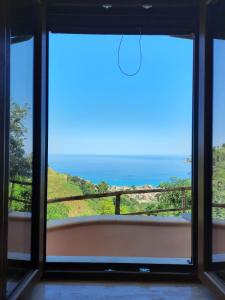 a room with a view of the ocean seen through a window at Vista mare rooms in Gasponi +8 photos