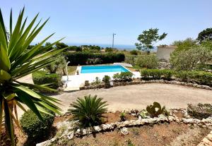 a garden with a swimming pool in the middle at Villa Rina in Avola
