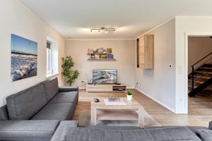 ein Wohnzimmer mit einem Sofa und einem Tisch in der Unterkunft Der Wattläufer in Ockholm