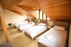 3 Betten in einem Zimmer mit Holzdecken in der Unterkunft Smestaj Paramun in Arilje