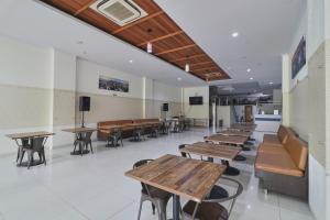 a cafeteria with wooden tables and chairs and desks at Aranis Hotel in Jakarta