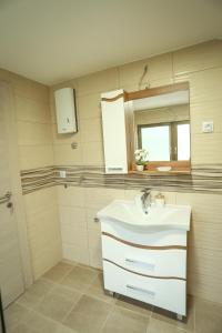 ein Badezimmer mit einem weißen Waschbecken und einem Spiegel in der Unterkunft Smestaj Paramun in Arilje
