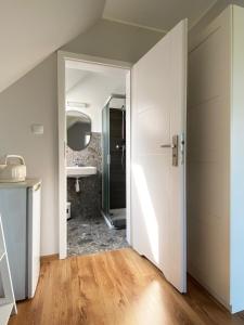 a bathroom with a sink and a mirror and a door at Nowa Kotwica in Jastrzębia Góra