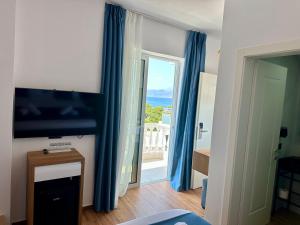 una stanza con una grande finestra con vista sull'oceano di ILLYRIAN hotel Ksamil a Ksamil