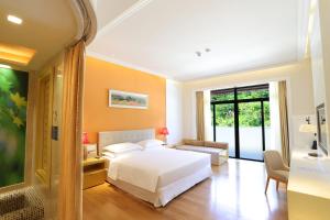 een slaapkamer met een wit bed en een groot raam bij Four Points by Sheraton Heyuan Resort in Heyuan