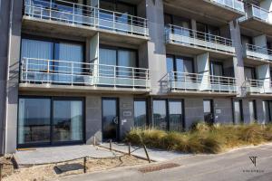 an apartment building with balconies on the side of it at L'arc en ciel in Bray-Dunes