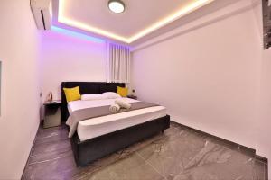 a bedroom with a bed with yellow and white pillows at חלום מול הים - סוויטת נופש יוקרתית עם ג'קוזי ונוף לים in Haifa