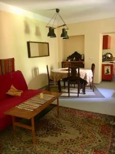 uma sala de estar com um sofá vermelho e uma mesa em Vintage studio apartment, GARDEN and FREE parking em Budapeste