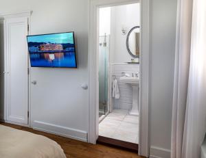 a white bathroom with a sink and a mirror at Poseidonion Grand Hotel in Spetses