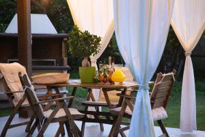a wooden table with chairs and a table with a umbrella at Neriana Villa - Garden Paradise in Chania Town