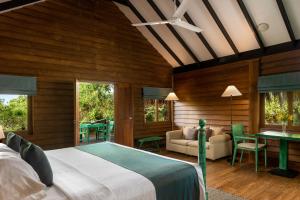 a bedroom with a bed and a living room at Jetwing Jungle Lodge, A Luxury Reserve in Yala