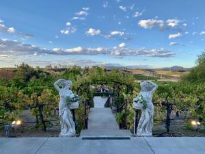 a ceremony aisle at a winery with two statues at Churon Inn Winery in Temecula