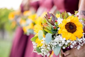 a group of people holding a bouquet of sunflowers at Churon Inn Winery in Temecula