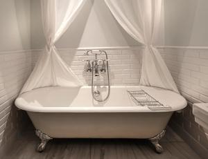 a white bath tub with a shower curtain in a bathroom at Poseidonion Grand Hotel in Spetses