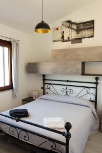una camera da letto con un grande letto con struttura nera di Is Seddas B&B a Bari Sardo