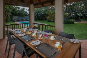 una larga mesa de madera con sillas y mesa en Fort D'Acre, en Port Alfred