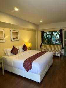a bedroom with a large white bed and a window at The One Sabai Living Pattaya in Pattaya