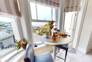 uma mesa com comida e bebidas numa sala com janelas em ILFRACOMBE SEA ROCK 4 1 Bedroom em Ilfracombe