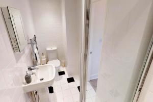 ein weißes Badezimmer mit Waschbecken und Dusche in der Unterkunft ILFRACOMBE SEA ROCK 4 1 Bedroom in Ilfracombe + 25 Fotos