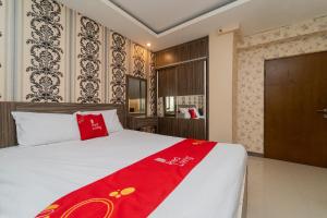 - une chambre avec un grand lit et une couverture rouge dans l'établissement RedLiving Apartemen Gateway Cicadas - Sarana Cipta Mahakarya, à Bandung