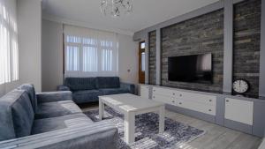uma sala de estar com um sofá e uma televisão em GRAND FAMILY HOME em Soğuksu