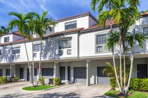 a white building with palm trees in front of it at Modern Townhouse Apartments near the Turnberry Golf Course, Aventura Mall, and Sunny Isles Beach in Aventura
