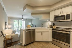 uma cozinha com armários brancos e um forno com placa de fogão em Modern Townhouse Apartments near the Turnberry Golf Course, Aventura Mall, and Sunny Isles Beach em Aventura