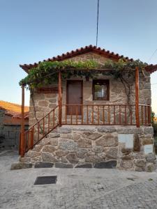 a stone house with a wooden porch and a balcony at Casa Largo S Lourenço e Casa da Videira 