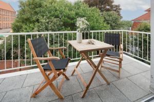 a wooden table and two chairs on a balcony at Ferienwohnung Schwalbennest in Norderney