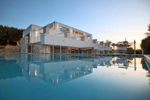 a house is reflected in the water of a pool at MEDITERRANEO RELAX in Polignano a Mare