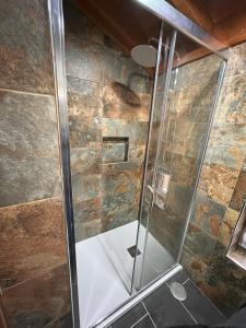 um chuveiro com uma porta de vidro na casa de banho em Casa Largo S Lourenço e Casa da Videira 