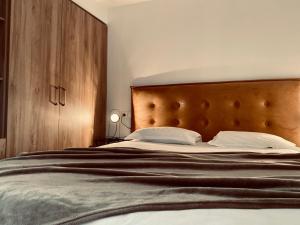 a bedroom with a large bed with a wooden headboard at Bella Vista Hôtel, Suites & Maisons in Porticcio