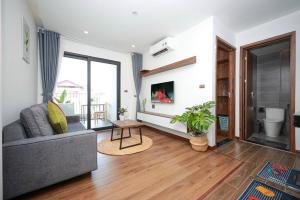 ein Wohnzimmer mit einem Sofa und einem TV in der Unterkunft Sweethome 121 Yen Phu Westlake Apartment in Hanoi