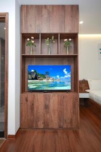 einen Fernseher in einem hölzernen Entertainment-Center in einem Zimmer in der Unterkunft Sweethome 121 Yen Phu Westlake Apartment in Hanoi