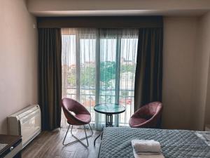een hotelkamer met een bed en twee stoelen en een raam bij Abazovic Apartments in Ulcinj