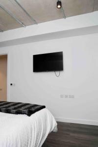 a bedroom with a flat screen tv on a wall at Charming 3-Bed Apartment in London in London