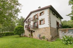 una vista exterior de una casa con patio en Ezkialderdi - baskeyrentals en Aia