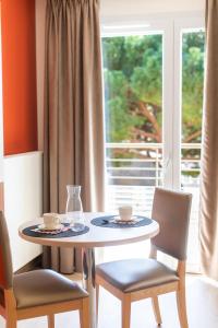 Fréjus Appart'S في فريجوس: طاولة مع كوبين وكراسي ونافذة