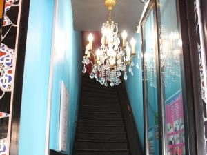 a staircase with a chandelier in a building at Hôtel Latino Reims Centre in Reims