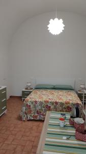 ein Schlafzimmer mit einem Bett mit einer Bettdecke und einem Tisch in der Unterkunft Bed and breakfast Puer Apuliae in Altamura